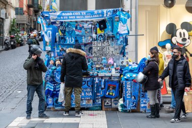 Napoli, İtalya - 24 Aralık 2021: Napoli futbol takımının araç gereçlerinin, aksesuarlarının ve kıyafetlerinin şehir sokaklarında mavi renkte satışı için oyalama.