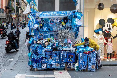 Napoli, İtalya - 24 Aralık 2021: Napoli futbol takımının araç gereçlerinin, aksesuarlarının ve kıyafetlerinin şehir sokaklarında mavi renkte satışı için oyalama.
