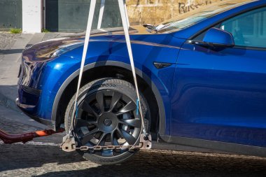 Napoli, İtalya - 25 Mart 2022: park yeri olmayan bir aracın çekici ile taşınması. Tesla marka elektrikli bir arabanın iyi ve kaldırılması.