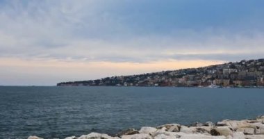 Napoli 'nin rıhtımı, İtalya. Posillipo Tepesi 'nin ufuk çizgisi ve yerleşim binaları olan şehir manzarası.