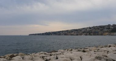 Napoli 'nin rıhtımı, İtalya. Posillipo Tepesi 'nin ufuk çizgisi ve yerleşim binaları olan şehir manzarası.