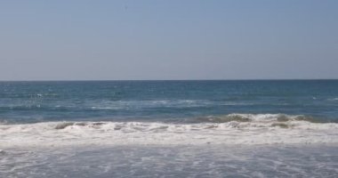 Denizin dalgaları sahilin kıyısında kırılır..