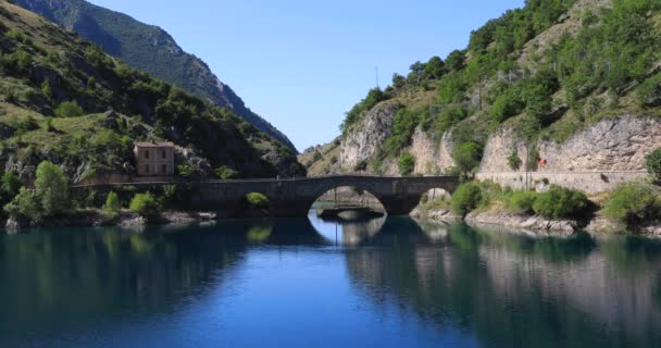 Small Lake Bridge Mirror Water Surrounded Mountains Rocky Spurs Green — 图库视频影像