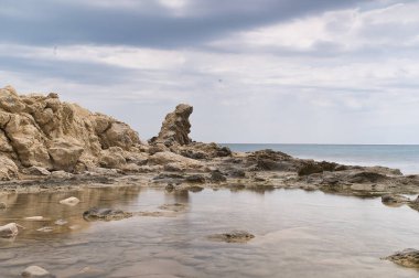 İspanya 'nın Alicante bölgesindeki Campello kasabasında kayalar, dalgalar ve köpüklerle dolu bir sahil.