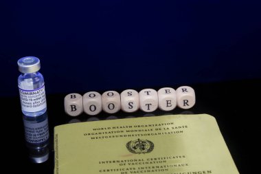 Bamberg, Almanya - 16.11.2021. Biontech-Pfizer 'dan Comirnaty şişesiyle aşılama sertifikası ve siyah-mavi, yansıtıcı arka planda 