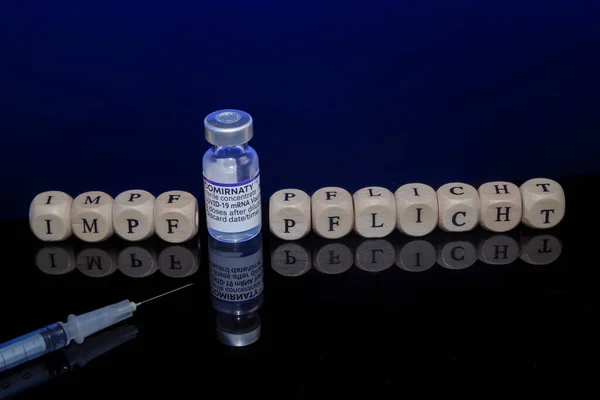 Bamberg, Alemania - 16.11.2021. Imagen conceptual vacunación obligatoria, cubos de letras, jeringa de vacunación y vial de vacunación con biontech-pfizer — Foto de Stock