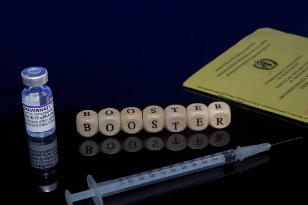 Bamberg, Alemania - 16.11.2021. Imagen conceptual del refuerzo de la vacunación, cubos de letras, jeringa, vial de biontech y certificado de vacunación — Foto de Stock