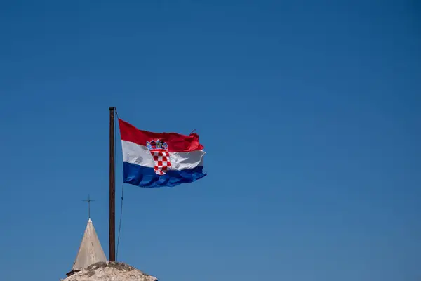 Κροατική σημαία κυματίζει στον άνεμο, μπλε καλοκαιρινός ουρανός ως φόντο — Φωτογραφία Αρχείου