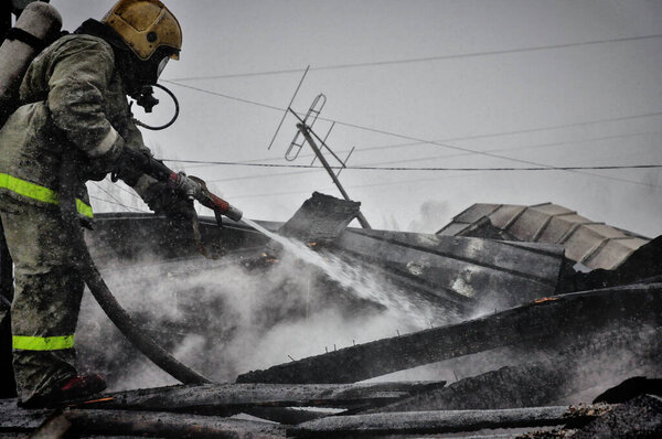 Пожарные с надписью на спине на русском языке "Охрана огня" тушат пожар