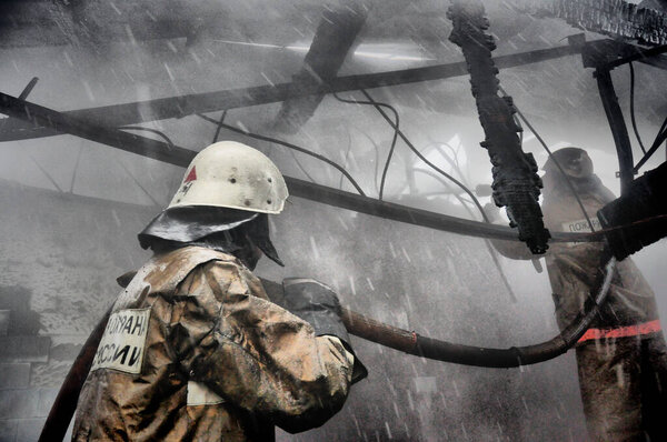 Пожарные с надписью на спине на русском языке "Охрана огня" тушат пожар