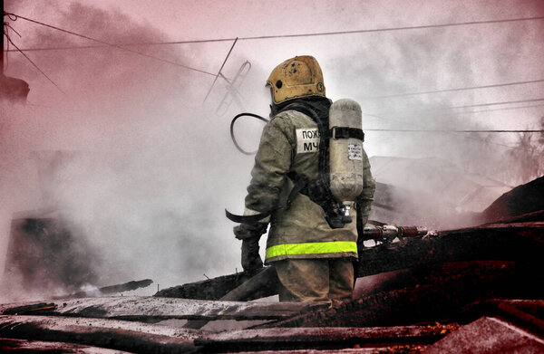 Пожарные с надписью на спине на русском языке "Охрана огня" тушат пожар