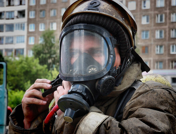 Барнаул, Россия - 24 мая 2019 года. Пожарные с надписью на спине на русском языке "Охрана огня" тушат пожар