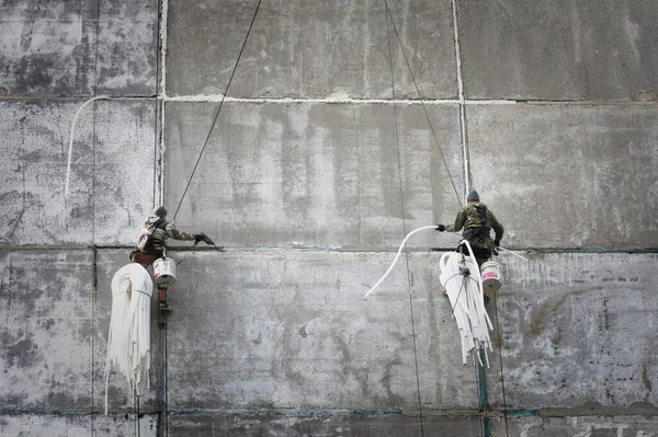 Rusya, Barnaul - 8 Eylül 2021. Endüstriyel tırmanışçılar bir panelin dikişlerini onarıyor.