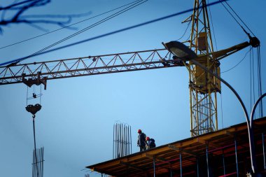  Kule vinçleri çok katlı bir binanın inşaatı üzerinde çalışıyor.