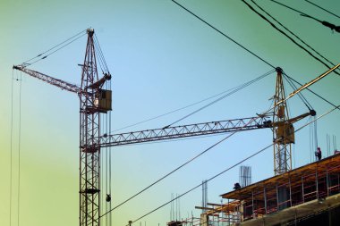  Kule vinçleri çok katlı bir binanın inşaatı üzerinde çalışıyor.