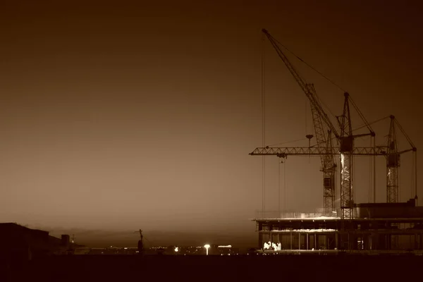 Guindastes Construção Estão Construindo Uma Casa Contra Fundo Pôr Sol — Fotografia de Stock