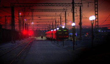 Elektrikli tren bir kış akşamı raylardan ayrılıyor.