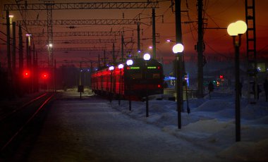 Elektrikli tren bir kış akşamı raylardan ayrılıyor.