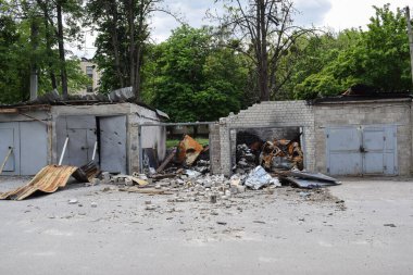 KHARKOV, UKRAINE - 25 Mayıs 2022: Rusya Ukrayna 'ya karşı savaş. Düşman topçu ateşiyle hasar gören bir garaj, yanıp kül olan bir araba.