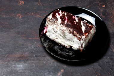 Tabakta bir dilim lezzetli çikolatalı pasta var. Ahşap arka planda lezzetli bir tatlı, yakın planda.