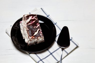 Tabakta bir dilim lezzetli çikolatalı pasta var. Ahşap arka planda lezzetli bir tatlı, yakın planda.