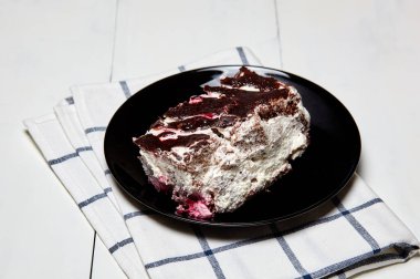 Tabakta bir dilim lezzetli çikolatalı pasta var. Ahşap arka planda lezzetli bir tatlı, yakın planda.