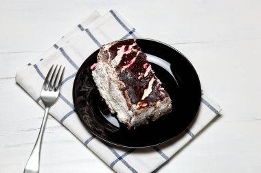 Tabakta bir dilim lezzetli çikolatalı pasta var. Ahşap arka planda lezzetli bir tatlı, yakın planda.