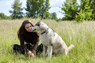 Sahibi kız sahada Sibiryalı köpeğiyle oynuyor. Köpekli mutlu bir kadın hafta sonu dışarıda iyi vakit geçirsin.