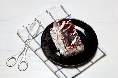 Tabakta bir dilim lezzetli çikolatalı pasta var. Ahşap arka planda lezzetli bir tatlı, yakın planda.