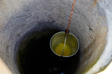 Avrupa köyünde metal bir kova var. Kırsal bölgedeki Retro Stone Kuyusu