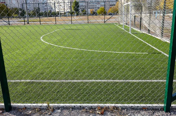 Γήπεδο Χλοοτάπητα Για Ποδόσφαιρο Πίσω Από Πράσινο Πλέγμα Φράχτη Κοντινό — Φωτογραφία Αρχείου