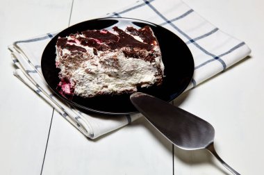 Tabakta bir dilim lezzetli çikolatalı pasta var. Ahşap arka planda lezzetli bir tatlı, yakın planda.