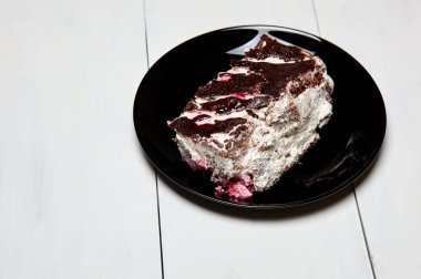 Tabakta bir dilim lezzetli çikolatalı pasta var. Ahşap arka planda lezzetli bir tatlı, yakın planda.