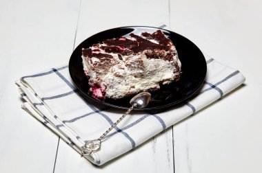 Tabakta bir dilim lezzetli çikolatalı pasta var. Ahşap arka planda lezzetli bir tatlı, yakın planda.