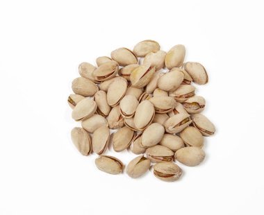 Beyaz arka planda izole edilmiş fıstık yığını. Kabuktaki şam fıstıklarının yakın çekimi.