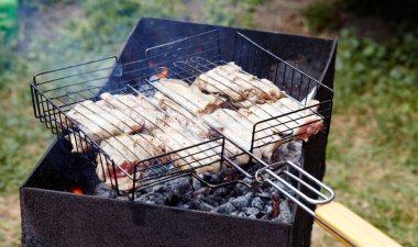 Izgarada pişen leziz tavuk kanatları, açık havada. Kızarmış tavuk eti, yakın plan.