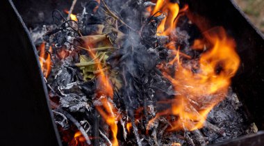 Yanan kırmızı kıvılcımlar ateşten uçar. Işıl ışıl yanan kömür ve yakacak odunları olan ızgara ızgarası.