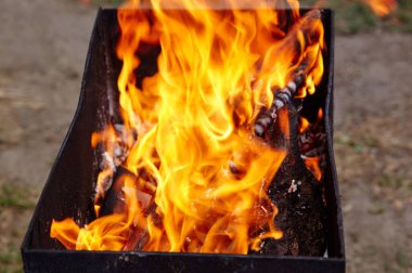 Yanan kırmızı kıvılcımlar ateşten uçar. Işıl ışıl yanan kömür ve yakacak odunları olan ızgara ızgarası.