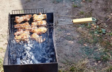 Izgarada pişen leziz tavuk kanatları, açık havada. Kızarmış tavuk eti, yakın plan.