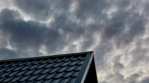 Construction of the roof of the house. Metal tiles against evening sky