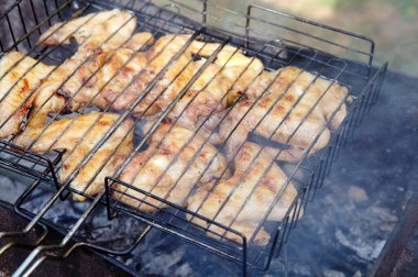 Izgarada pişen leziz tavuk kanatları, açık havada. Kızarmış tavuk eti, yakın plan.