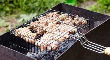 Izgarada pişen leziz tavuk kanatları, açık havada. Kızarmış tavuk eti, yakın plan.