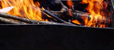 Yanan kırmızı kıvılcımlar ateşten uçar. Işıl ışıl yanan kömür ve yakacak odunları olan ızgara ızgarası.