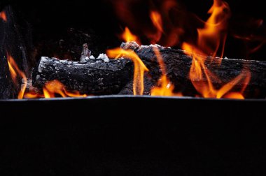 Yanan kırmızı kıvılcımlar ateşten uçar. Işıl ışıl yanan kömür ve yakacak odunları olan ızgara ızgarası.