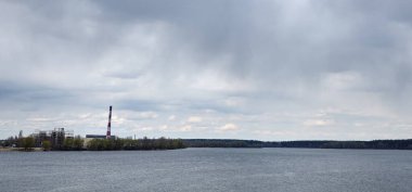 Enerji santralinin manzarası doğanın arka planına karşı. Bir su kütlesinin arka planında elektrik santralinin görüntüsü