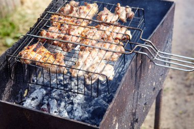 Izgarada pişen leziz tavuk kanatları, açık havada. Kızarmış tavuk eti, yakın plan.