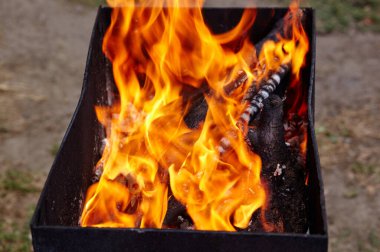 Yanan kırmızı kıvılcımlar ateşten uçar. Işıl ışıl yanan kömür ve yakacak odunları olan ızgara ızgarası.