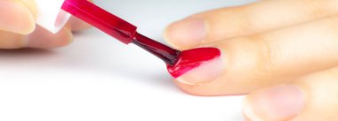 Kadın kırmızı oje sürüyor.