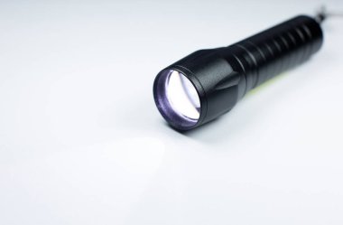 Siyah el feneri ve beyaz arka planda bir ışık demeti. Fotoğrafı kapat..