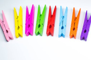 Beyaz arka planda renkli ahşap mandallar. Kapat, boşluğu kopyala.